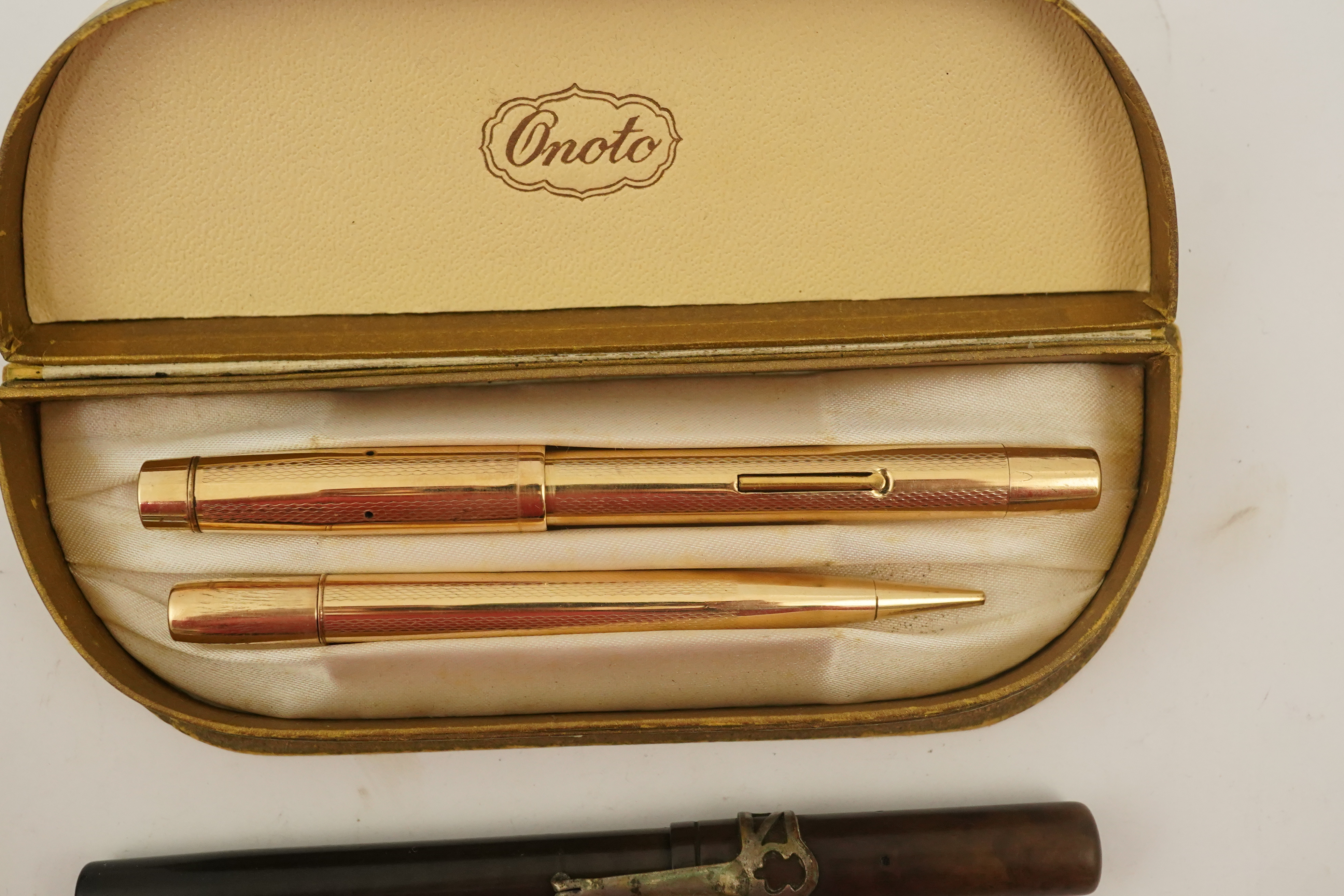 A novelty gun propelling pencil, a gold plated De La Rue Onoto fountain pen and matching pencil, in original box and two other items